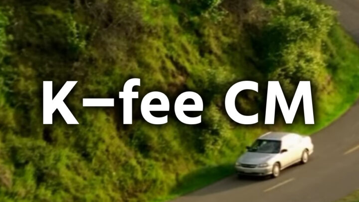 「K-fee CM」という影付きの白文字が、緑豊かな丘の道を走る車の写真を背景に書かれている。