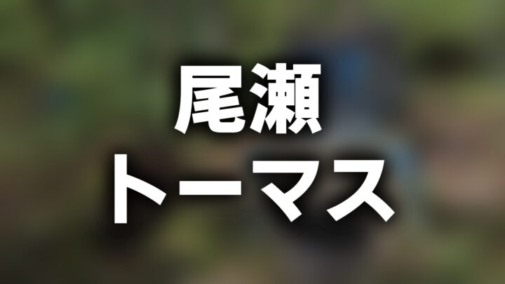 「尾瀬 トーマス」という影付きの白文字が、ぼかした写真の上に書かれている。